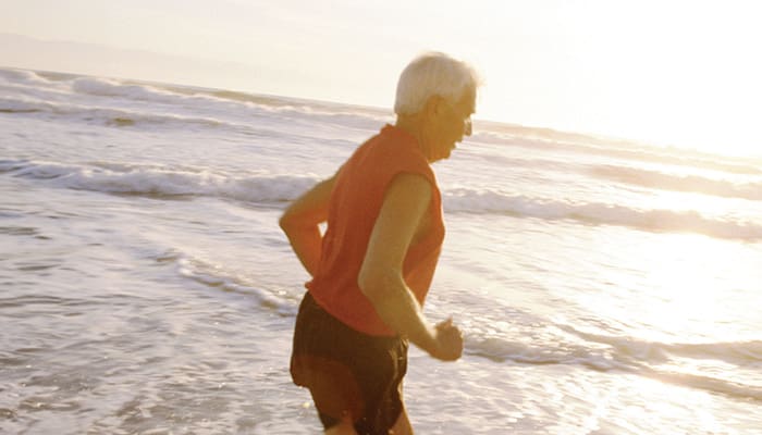 Senior man running alongside the beach