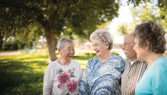 Portrait of a smiling group walking around the Claremont Manor grounds