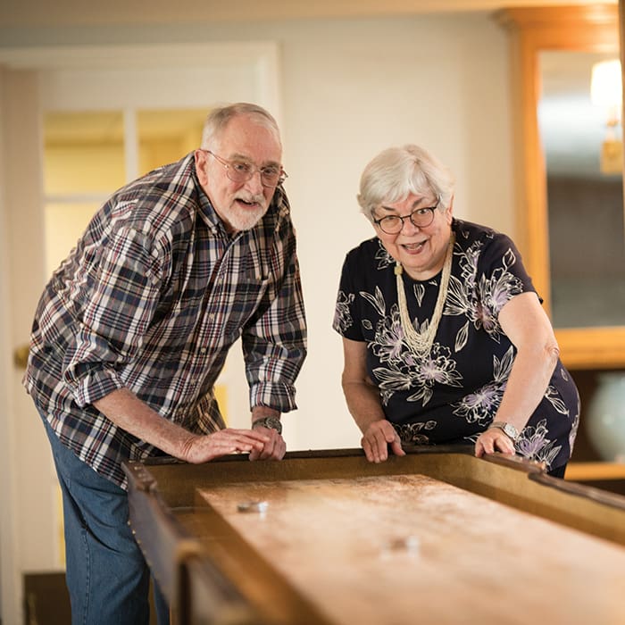 Portrait of a smiling couple enjoying a game offered at Claremont Manor