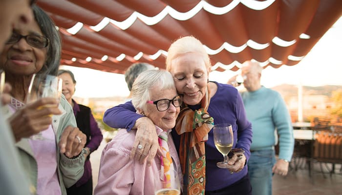 Portrait of a smiling group enjoying the Kingsley Manor rooftop