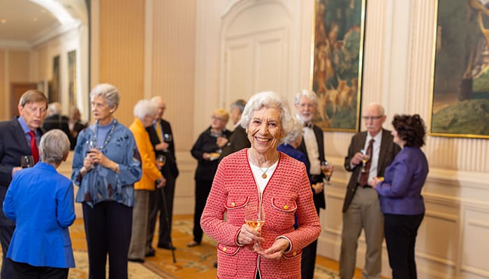 resident holding up wine glass at a community gathering