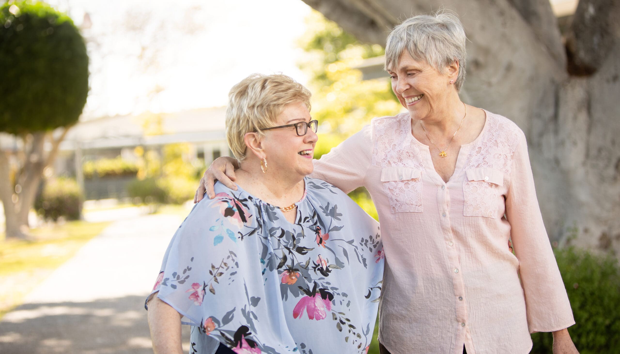 Portrait of two women standing outside with arms around each other at Wesley Palms