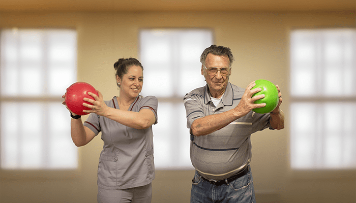 Trainer works with a resident during a rehabilitation session